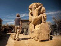 Sculptor David Falossi beside his hand-carved limestone sculpture Spirit Climb